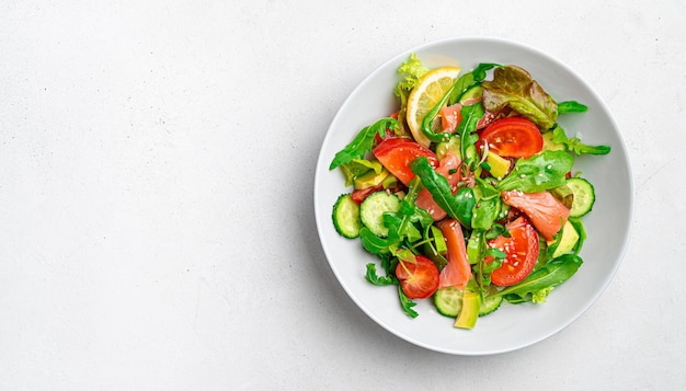 Ensalada con verduras de salmón y hierbas frescas sobre un fondo claro Ensalada dietética saludable