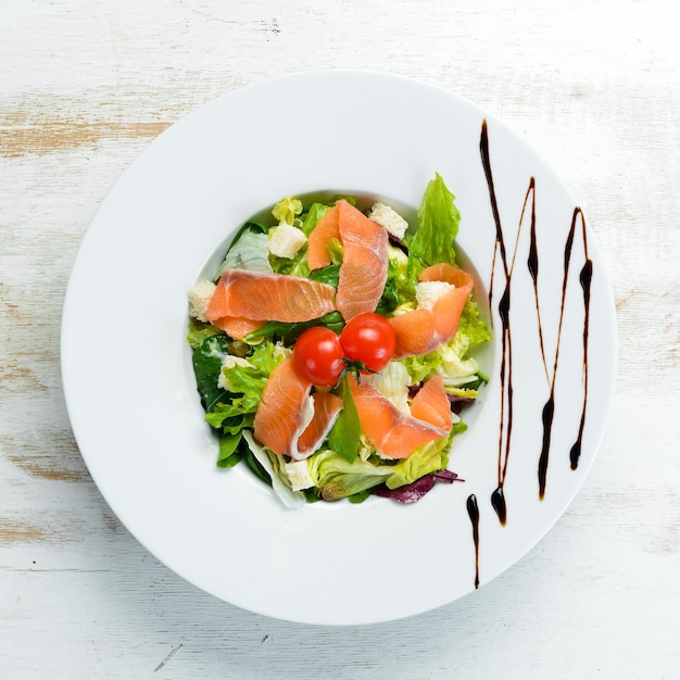 Ensalada de verduras con salmón salado y tomates cherry. Ensalada César con salmón. Vista superior. Espacio libre para su texto.