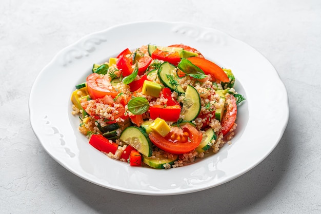 Ensalada de verduras saludables con quinua y hierbas frescas sobre un fondo gris Vista lateral de primer plano