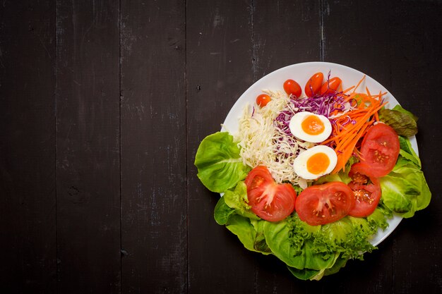 Ensalada de verduras sobre fondo de madera negra