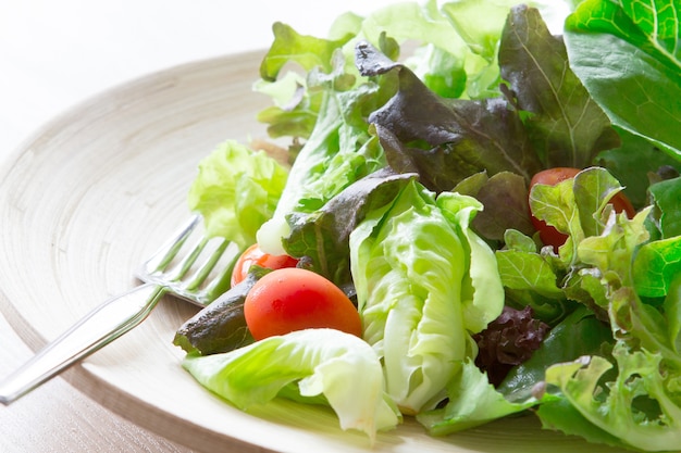 Ensalada de verduras en un tazón de madera, comida sana