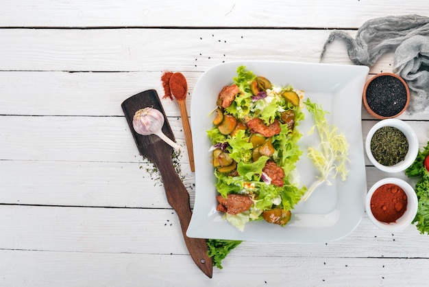 Ensalada de verduras con ternera y pepino Vista superior Sobre un fondo de madera Espacio de copia