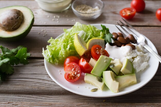 ensalada de verduras con tomate, aguacate, lechuga, frijoles, ricotta