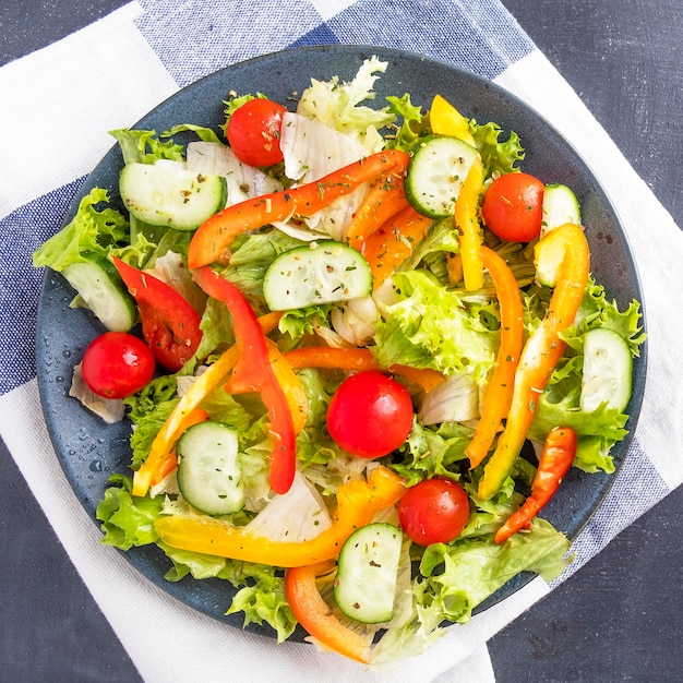 Ensalada de verduras con tomate pimiento y pepino en un plato Vista superior