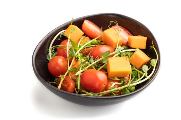 Ensalada de verduras vegetarianas de tomates, calabaza, brotes de guisantes microverdes aislados en blanco