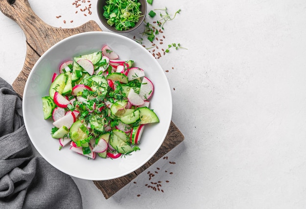 Ensalada de verduras de verano con rábanos sobre un fondo gris