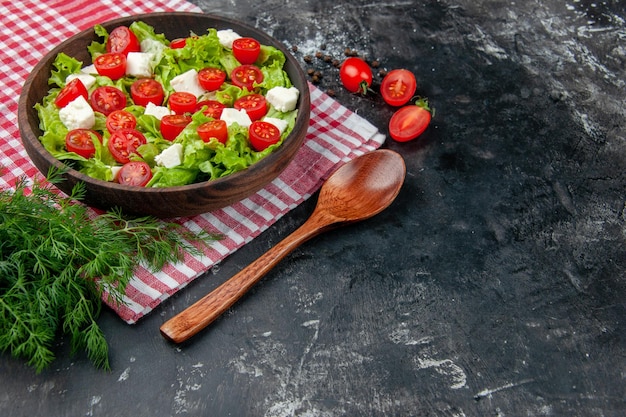 Ensalada de verduras de vista frontal con tomates con queso en rodajas y condimentos sobre fondo oscuro comida comida dieta almuerzo color de salud