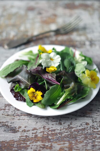 Ensalada con violetas en un plato blanco