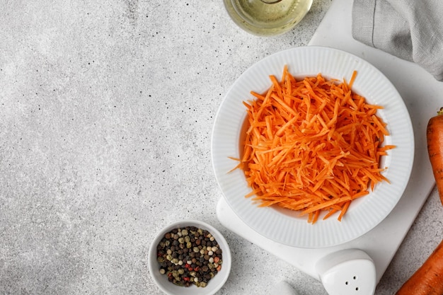 Ensalada de zanahoria comprada en un tazón blanco Concepto de comida dietética Detox Fondo gris