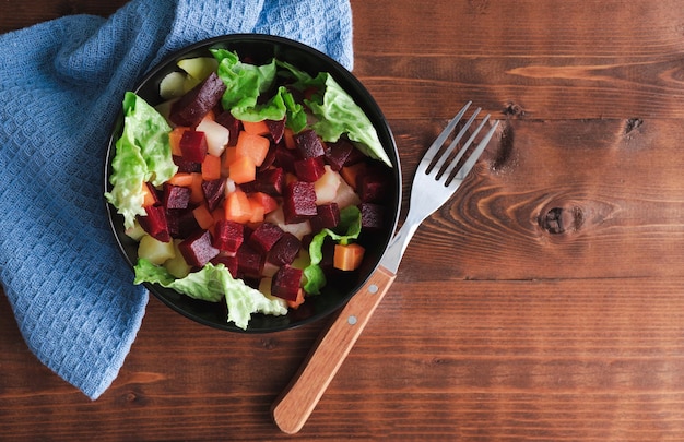 Ensalada de zanahoria y lechuga de remolacha en un tazón sobre fondo de madera Espacio de copia Vista superior