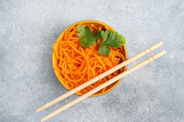 Ensalada de zanahoria picante rallada cruda en un recipiente