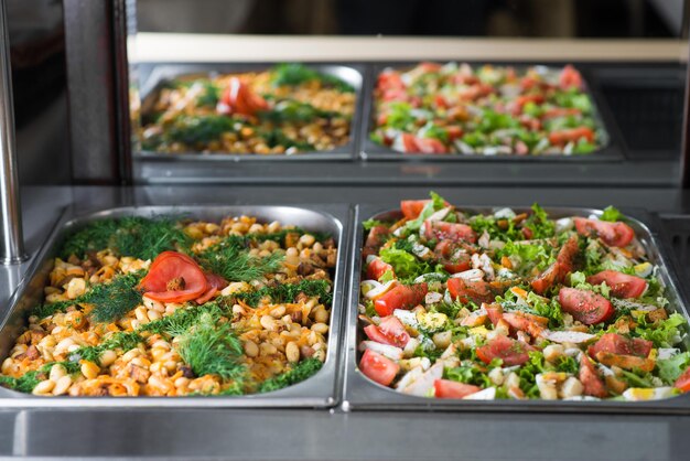 Ensaladas frescas en calderas en la mesa de buffet