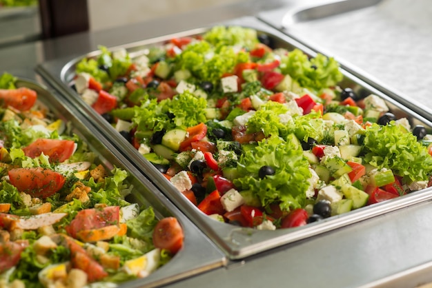 Ensaladas frescas en calderas en la mesa de buffet