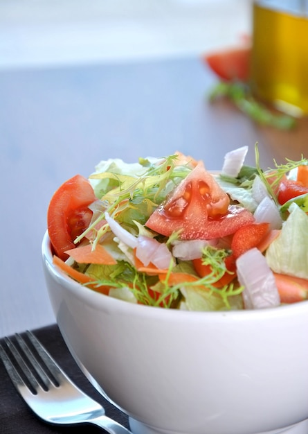 Foto ensaladera con lechuga, zanahoria, tomate y cebolla.