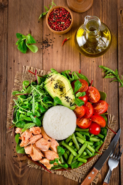 Ensaladera saludable con salmón, arroz, tomate, aguacate, ensalada mixta, judías verdes