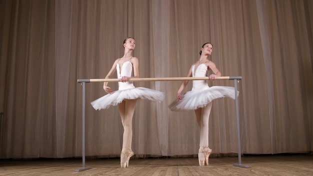 Ensayo de ballet en la vieja sala de teatro jóvenes bailarinas con faldas de ballet blancas tutus