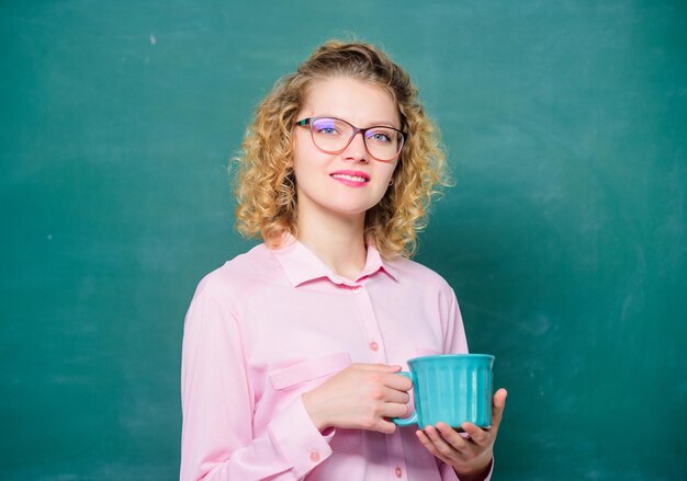 La enseñanza es el mayor acto de optimismo. La mujer disfruta de un café antes de las clases escolares. Carga de energía para todo el día. Adicto al café. Dosis de cafeína. Profesor en vasos beber fondo de pizarra de café.