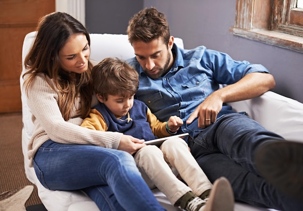 Enseñarle sobre la tecnología de pantalla táctil Foto de una familia amorosa usando una tableta digital juntos