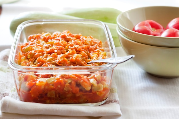 Ensopado de abóbora com cenoura e tomate em um prato quadrado de vidro