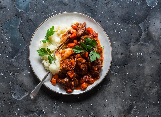 Ensopado de carne de Borgonha com purê de batatas em uma vista superior de fundo escuro Deliciosa comida caseira de conforto