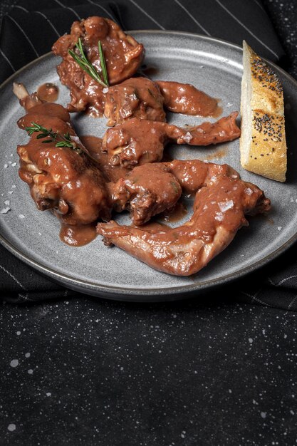 Ensopado de carne de coelho caseiro tradicional com molho de vinho tinto com ervas aromáticas em fundo preto