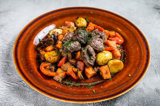 Foto ensopado de carne, goulash em um prato. fundo branco. vista do topo.