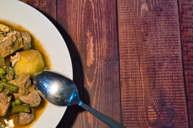 Foto ensopado de carne no seu prato em um conceito de dia mundial da comida de fundo de madeira