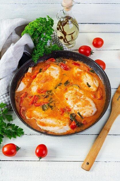 Ensopado de peito de frango com tomate, pimenta e espinafre na panela