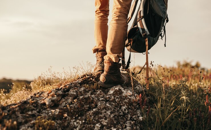 Entdecker mit Rucksack stehend auf rauem Felsen