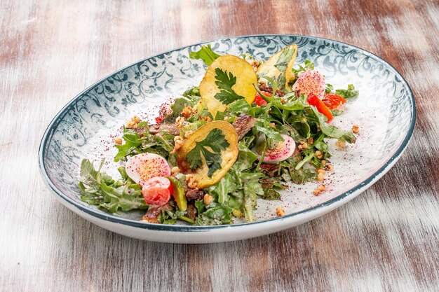 Entenbrustsalat mit Kartoffelchips und frischem Gemüse Auf einem dekorativen Teller