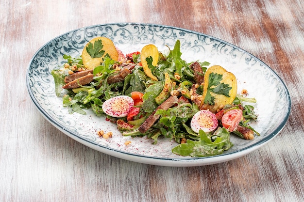 Entenbrustsalat mit Kartoffelchips und frischem Gemüse Auf einem dekorativen Teller