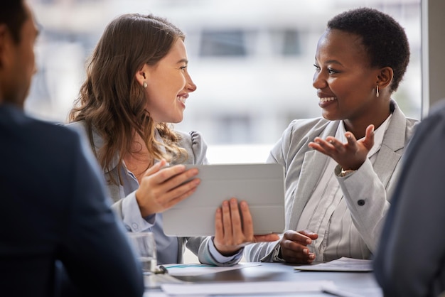 Entendo exatamente o que você quer dizer Foto de duas jovens empresárias sentadas juntas no escritório e conversando enquanto usam um tablet digital