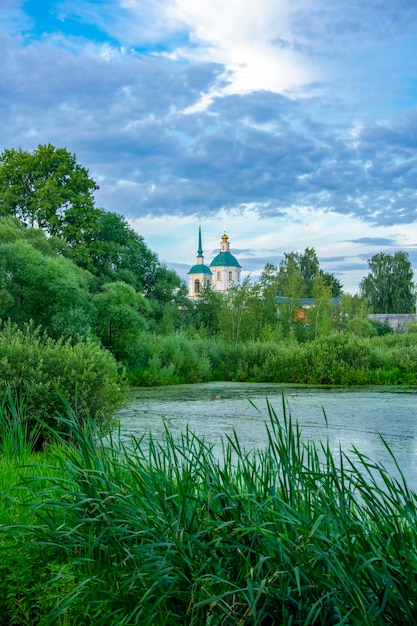 Foto entengrütze bedeckter see kiovo region moskau russland orthodoxe kirche am ufer mit schilf bewachsen am sommerabend