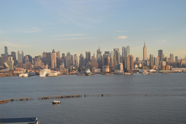 Entfernter Blick auf das Empire State Building in der Stadt am Fluss gegen den Himmel