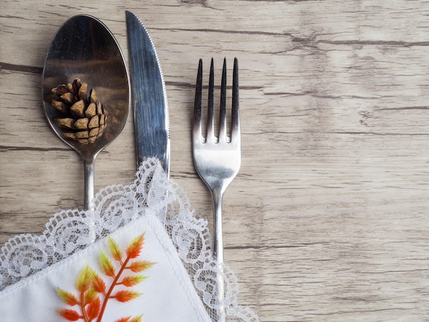 Entorno festivo para la cena navideña o de acción de gracias Cubiertos antiguos en la servilleta blanca sobre fondo de madera antiguo con espacio para copiar