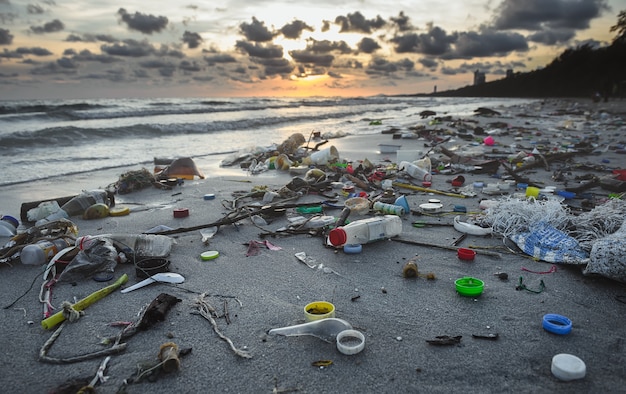 Foto entorno de playa sucia de basura plástica