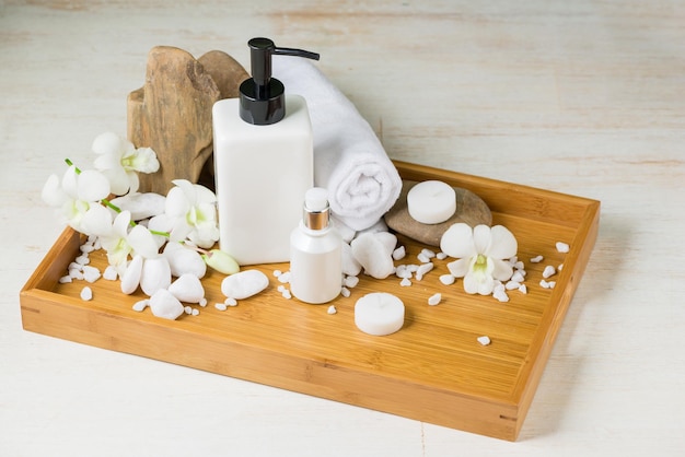 Entorno de spa con botellas de orquídeas de sal de aceite esencial en un tazón vela ballcreamorchid herbal