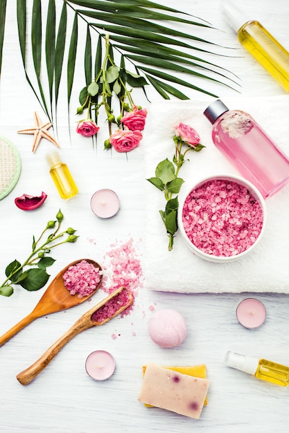 Entorno de spa con rosas rosadas, sal marina y aceite aromático, estilo vintage