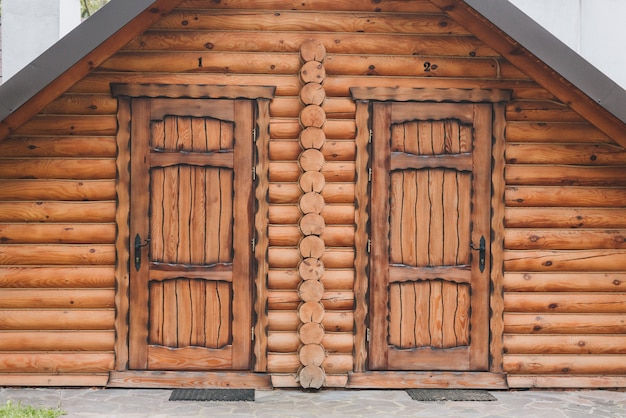 Entrada a una casa de madera con dos puertas simétricas.