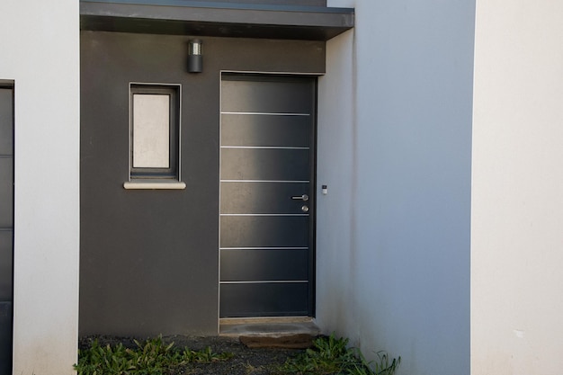 Entrada de casa moderna de puerta gris con fachada gris blanca contemporánea