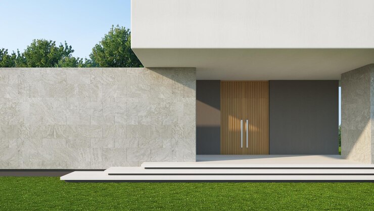 Entrada de la casa con muro de piedra y césped