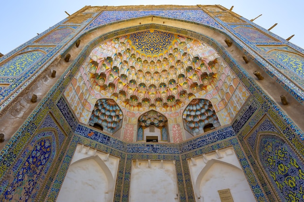 Entrada colorida ao antigo edifício religioso com decoração tradicional Bukhara Uzbequistão