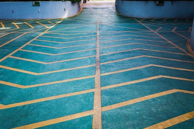 Entrada de estacionamento com sinais de subida de asfalto e placa de canto branca