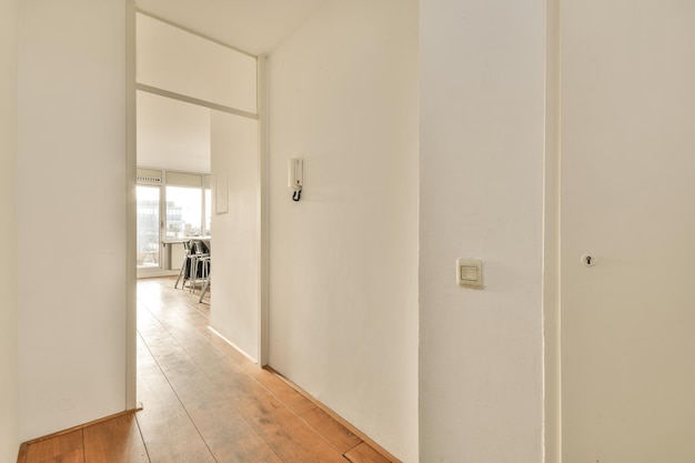 Entrada do apartamento moderno com paredes brancas e piso em parquet