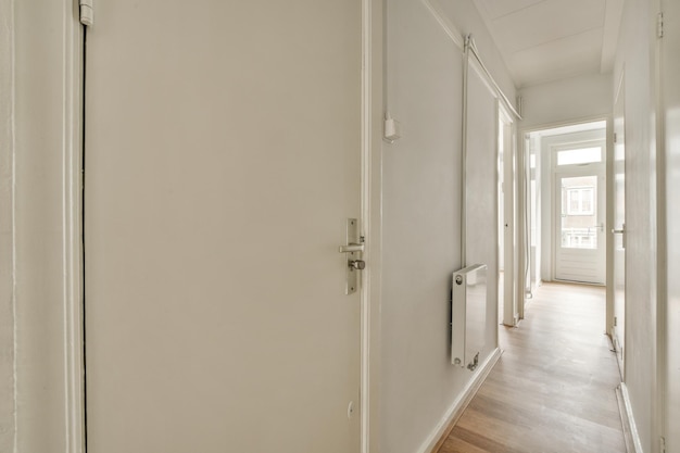 Entrada do apartamento moderno com paredes brancas e piso em parquet