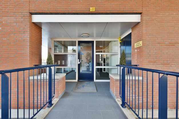 Foto la entrada a un edificio de ladrillo con una puerta azul.