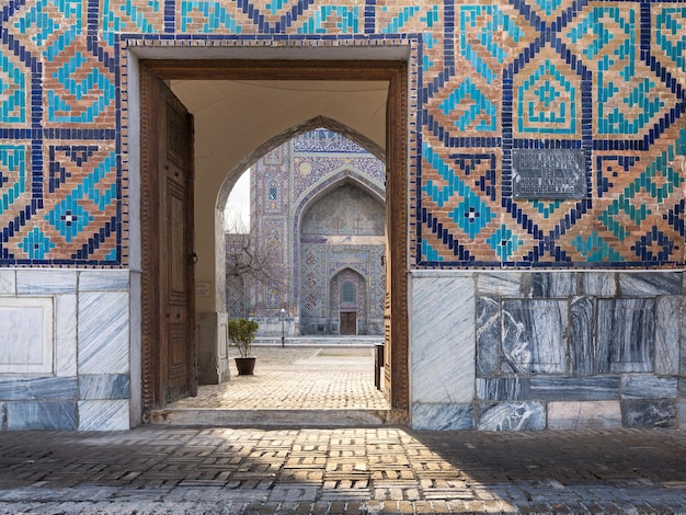 Entrada para o antigo pátio tradicional uzbeque da madrassa Samarcanda Uzbequistão