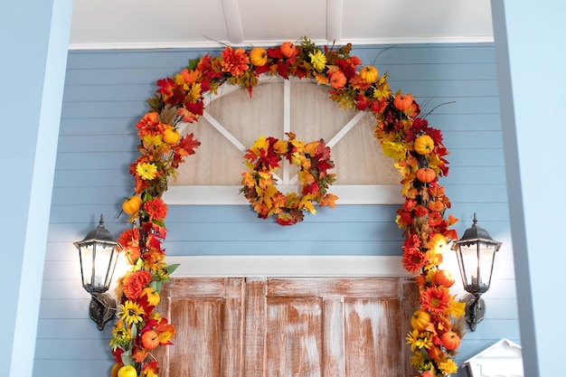 Entrada de la puerta de la casa decorada con hojas de guirnaldas de otoño para Halloween