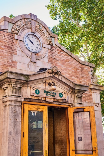 Entrada de la superficie de la estación de metro en la ciudad de Nueva York Bowling Green piedra caliza y ladrillos con reloj