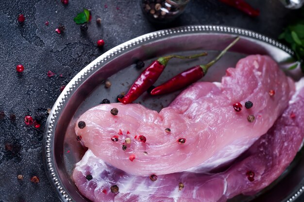 Entrecosto de bife de carne fresca crua e temperos na chapa de ferro com óleo, pimentão, especiarias dill